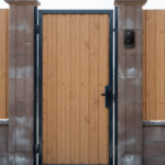 Closed metal fence with a wicket, texture of profiled metal, security and privacy concept